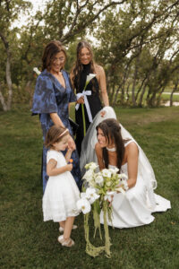 bride showing her flowers to her flower girl. Documentary style photos.