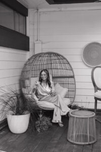 girl smiling at phone and drinking a mimosa in her wedding pjs.