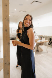 Bridesmaid laughing and crying looking at bride.