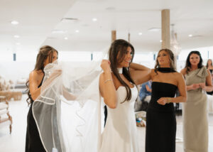 Bridesmaid adjusting brides veil.